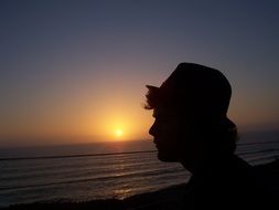 silhouette of a man near the ocean during sunset