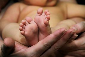 Baby feet on mother's hands