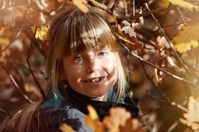 child girl face blond hair tree leaves