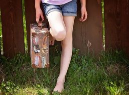 barefoot girl with suitcase