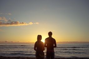 Brother and sister are on a beach at the sunset