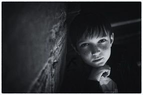 young boy at wall, black and white portrait