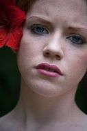 A teenage girl with a natural make-up and flower in her hair
