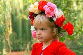 baby girl blonde with a wreath of flowers on her head