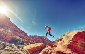 man jumping hills sunrise view