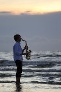 Man is playing on a saxophone