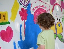child paints on the wall