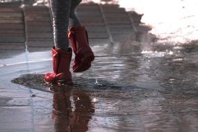 Human in a boots walking on a puddles