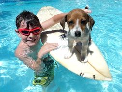 child boy with surfing board and doggy