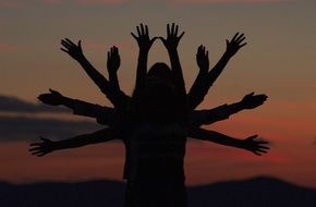 people arms' silhouette at dusk