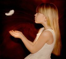 little girl plays with a white feather