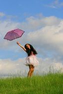 girl with a pink umbrella on a background of blue sky