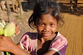 little girl with buds in her hand in cambodia