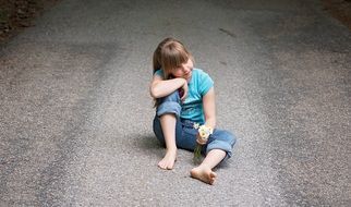 child sitting on the road