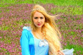 Girl with blond hair in a crown like a princess on a background of nature in spring