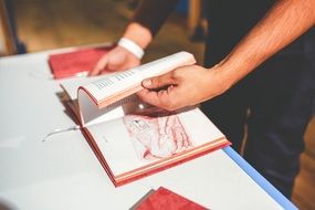male hands turning over book pages