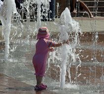 girl playing with fountain