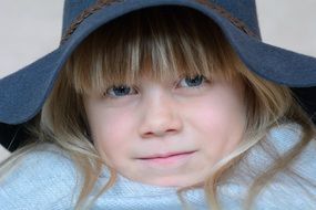 blonde girl face in hat blue eye