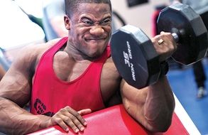 man shakes his biceps with dumbbells