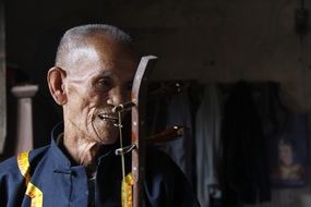 old man plays a national instrument
