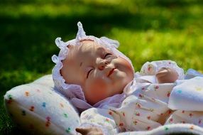 newborn baby sleeps on green grass