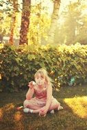 girl blows soap bubbles in a park