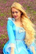 blonde girl in a princess dress on the background of spring nature