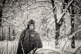 black and white photography of a lady in winter forest