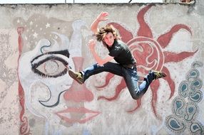 man jumping on the background of a concrete wall