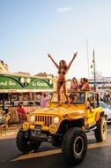 girls in bikini on a yellow jeep at a fun party