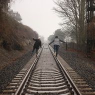 the couple walks along the rails