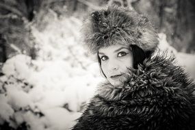 black and white picture of a woman in winter forest
