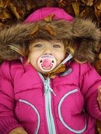 baby in a bright jacket in autumn