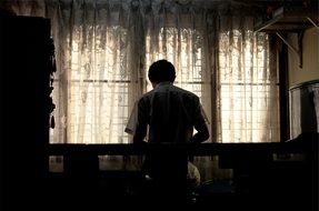 man sits at a table in a dark room