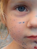 girl's face soiled by with blue paint