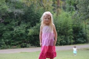 blonde girl in pink white dress park view