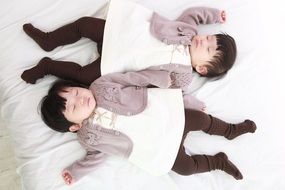children twins sleep on the white bed