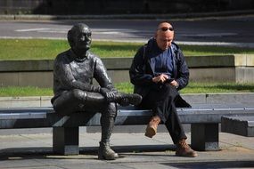 bronze sculpture and businessman on a bench