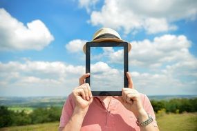 person in hat abstract ipad no face cloud sky