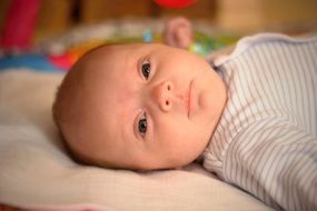 baby girl lying on back looking straight