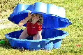 child in the meadow playing with summer toys