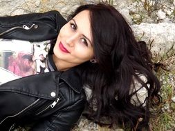 portrait of the girl with black hair lying on a stone