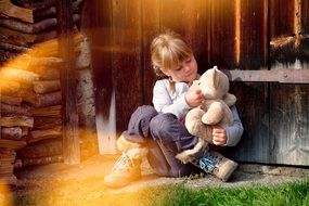 Girl white teddy bear lighting near wooden wall