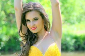 Beauty of girl with bright makeup in a yellow dress