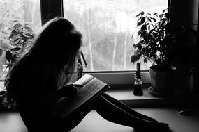 silhouette of a reading girl