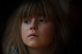 Young girl face dark photo