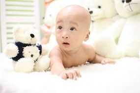 the cute asian baby on background plush bears