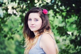 beautiful girl with a pink rose in her hair