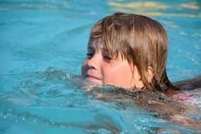 happy child girl swimming in pool