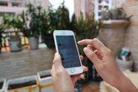 Iphone 5s in hand close-up on blurred background